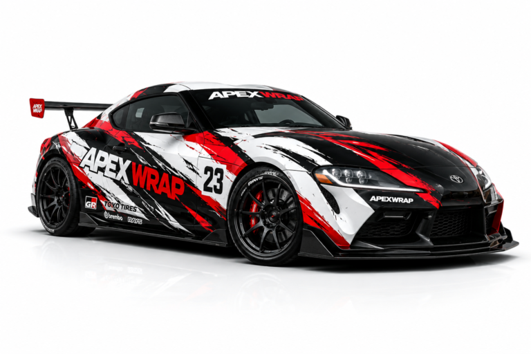 Black, red, and white racing car wrap kit on a modified sports coupe parked in an industrial yard at sunset.